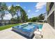 Inviting backyard pool with a spa, waterfall feature, and lush green landscaping creates a serene outdoor oasis at 9080 Morgana Ct, Winter Garden, FL 34787