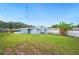 Well-maintained backyard with a blue house, lush green grass, and banana trees along the fence at 1022 Baycrest Dr, Lakeland, FL 33805