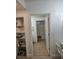 A bathroom is seen from a doorway, with a view of tile flooring, shelves, and a bathtub at 7601 Canada Ave # 220, Orlando, FL 32819