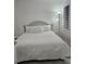 Calm bedroom featuring a neatly made queen-sized bed with white bedding and natural light from the shuttered window at 7601 Canada Ave # 220, Orlando, FL 32819