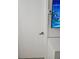 Hallway doorway leading to room with white door, silver handle, thermostat, and television at 7601 Canada Ave # 220, Orlando, FL 32819