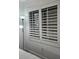 Bedroom window with white shutters and a floor lamp in a cozy bedroom interior at 7601 Canada Ave # 220, Orlando, FL 32819
