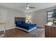 Cozy bedroom featuring a ceiling fan, wood floors, and a decorative headboard at 107 Elm N Sq, Lakeland, FL 33813