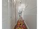 Hallway with white closet doors, neutral walls and a colorful rug at 107 Elm N Sq, Lakeland, FL 33813