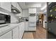 Modern kitchen featuring white cabinets, stainless steel appliances and wood-look tile flooring at 107 Elm N Sq, Lakeland, FL 33813