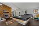 Spacious living room with a pool table, wood floors, and a cozy seating area at 107 Elm N Sq, Lakeland, FL 33813