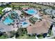An aerial view of a resort-style community pool area with multiple pools, lounge chairs, and palm trees at 1423 Bunker Dr, Davenport, FL 33896