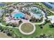 Aerial view of a community pool, clubhouse, green space, and recreational amenities with palm trees at 1423 Bunker Dr, Davenport, FL 33896
