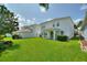 Expansive backyard featuring a well-manicured lawn and white home exterior, perfect for outdoor enjoyment and entertaining at 1423 Bunker Dr, Davenport, FL 33896