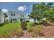 Lush backyard featuring a manicured lawn, covered patio, vibrant flower beds, and mature trees for enhanced privacy at 1423 Bunker Dr, Davenport, FL 33896