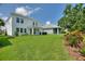 Spacious backyard featuring a lush lawn, covered patio, and meticulously landscaped surroundings, perfect for relaxation at 1423 Bunker Dr, Davenport, FL 33896