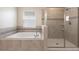 Bright bathroom featuring a soaking tub and a glass enclosed shower at 1423 Bunker Dr, Davenport, FL 33896