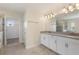 Modern bathroom featuring dual sinks, white cabinets, and a large mirror above at 1423 Bunker Dr, Davenport, FL 33896