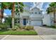 Charming two-story home featuring a well-manicured lawn, colorful landscaping, and a two-car garage at 1423 Bunker Dr, Davenport, FL 33896