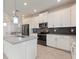 This is a kitchen with white cabinets, stainless steel appliances, and a dark backsplash at 1423 Bunker Dr, Davenport, FL 33896
