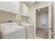 Well-equipped laundry room with cabinets, washer, and dryer at 1423 Bunker Dr, Davenport, FL 33896