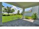 Inviting covered patio featuring stone pavers and peaceful views of the lush, green lawn and well-maintained landscaping at 1423 Bunker Dr, Davenport, FL 33896