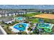 This aerial view showcases a community pool and splashpad with slides and ample seating for residents to enjoy at 1423 Bunker Dr, Davenport, FL 33896