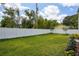 Large grassy backyard enclosed by a white fence, providing a secure and private outdoor area at 216 E Harding St, Orlando, FL 32806