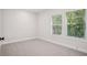 Bright bedroom with neutral carpet, two windows bringing in natural light, and white trim at 216 E Harding St, Orlando, FL 32806