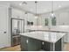 Stylish kitchen featuring a large island, stainless steel appliances, and modern fixtures at 216 E Harding St, Orlando, FL 32806