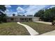 Charming single-story home with a long driveway, lush lawn and covered porch at 3115 Lake Arnold Pl, Orlando, FL 32806