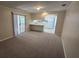 Open-concept living area with carpet, connecting to the kitchen, with sliding doors to patio at 3115 Lake Arnold Pl, Orlando, FL 32806
