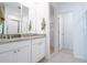 Bright bathroom with double sinks, granite countertops, white cabinets, and a view of the shower and closet at 573 Vista Villages Blvd, Davenport, FL 33896