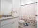 Clean bathroom with granite countertop, white cabinetry, and decorative shower curtain at 573 Vista Villages Blvd, Davenport, FL 33896