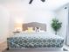 Comfortable bedroom featuring a large bed with stylish pillows and blankets, a plant, and a neutral color palette at 573 Vista Villages Blvd, Davenport, FL 33896