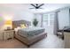 Bright bedroom featuring a ceiling fan, a large window, and a comfortable bed with stylish pillows and blankets at 573 Vista Villages Blvd, Davenport, FL 33896