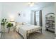 Bright bedroom with a metal-framed bed, neutral bedding, stylish decor, and ample natural light filtering through the window at 573 Vista Villages Blvd, Davenport, FL 33896