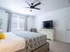 Bright bedroom with a modern ceiling fan, comfortable bed, large dresser, and sleek TV at 573 Vista Villages Blvd, Davenport, FL 33896