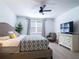 Cozy bedroom showcasing a ceiling fan, a modern TV, a large window, and a comfortable bed at 573 Vista Villages Blvd, Davenport, FL 33896