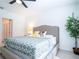 Comfortable bedroom with a modern ceiling fan, stylish bed, and a bathroom visible through the doorway at 573 Vista Villages Blvd, Davenport, FL 33896