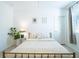 Bright bedroom with a metal-framed bed, neutral bedding, stylish decor, and ample natural light filtering through the window at 573 Vista Villages Blvd, Davenport, FL 33896