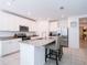 Bright kitchen with stainless steel appliances, granite countertops, tile floor, and a functional island with barstool seating at 573 Vista Villages Blvd, Davenport, FL 33896
