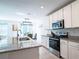 Bright kitchen with stainless steel appliances, granite countertops, tile floor, and a functional island with barstool seating at 573 Vista Villages Blvd, Davenport, FL 33896