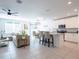 Open-concept living area with kitchen island, dining table, comfortable sofa, and ample natural light, perfect for modern living at 573 Vista Villages Blvd, Davenport, FL 33896