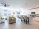 Open-concept living area with kitchen island, dining table, comfortable sofa, and ample natural light, perfect for modern living at 573 Vista Villages Blvd, Davenport, FL 33896