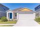 Charming single-Gathering home with a bright blue front door and attached two car garage at 766 Ambleside Dr, Haines City, FL 33844