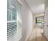 Hallway featuring wood floors, neutral paint, a window with blinds, and entry to other rooms at 766 Ambleside Dr, Haines City, FL 33844