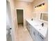 Bathroom featuring double sinks, granite countertops, and walk-in closet access at 1510 Avleigh Cir, Orlando, FL 32824