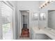 Bright bathroom featuring a wide mirror with Hollywood-style lighting and an entryway to another room at 433 Woodcrest St, Winter Springs, FL 32708
