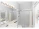 Bright bathroom featuring a shower with white tiling, and a wide mirror with Hollywood-style lighting at 433 Woodcrest St, Winter Springs, FL 32708