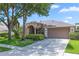 Charming single-story home with a well-manicured lawn, mature trees, and a two-car garage at 433 Woodcrest St, Winter Springs, FL 32708