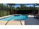 Sparkling pool with a built-in spa in a screened enclosure, surrounded by lush landscaping and comfortable seating at 433 Woodcrest St, Winter Springs, FL 32708