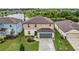 Aerial view of a two-story home with a gray two-car garage, lush lawn, and pond view, ideal setting at 5660 Keaton Springs Dr, Lakeland, FL 33811