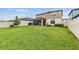 Large backyard featuring lush green grass, covered patio, and a privacy fence, perfect for outdoor gatherings at 5660 Keaton Springs Dr, Lakeland, FL 33811