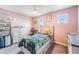 Charming bedroom with pink walls and a cozy bed, complemented by a ceiling fan at 5660 Keaton Springs Dr, Lakeland, FL 33811